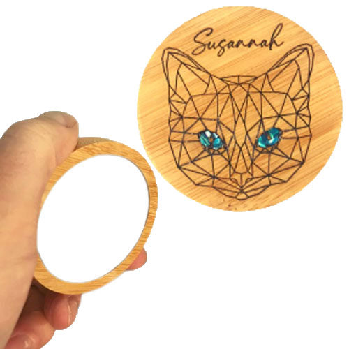 a hand shows the size of bamboo mirror with cat mandala