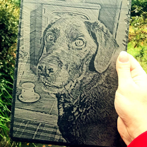 a hand holding the finished pet dog memorial engraved on slate