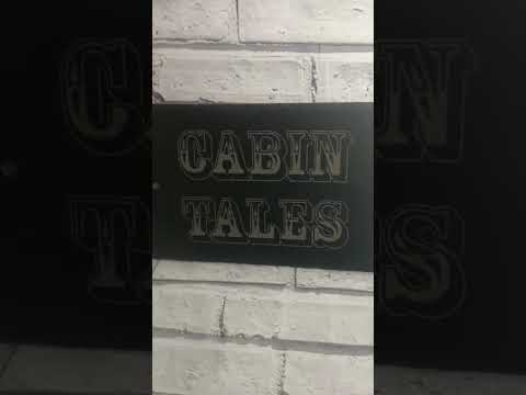 video of a finished slate engraved with the words Cabin Tales for a man-shed